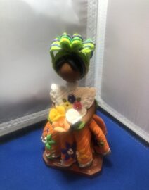 Colorful handmade folk doll holding flowers