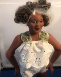Doll with gray-streaked hair in eyelet dress