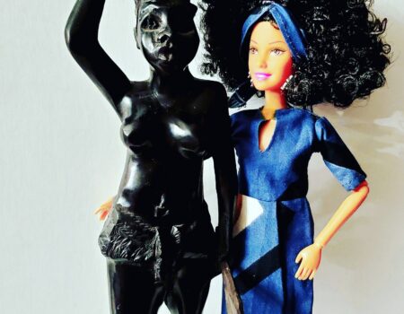 Doll with afro beside black female statue Doll with afro beside black female statue