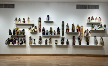 Handcrafted dolls displayed on gallery shelves Handcrafted dolls displayed on gallery shelves