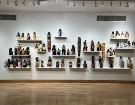 Handcrafted dolls displayed on gallery shelves Handcrafted dolls displayed on gallery shelves