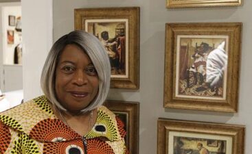 Woman standing next to framed historical portraits Woman standing next to framed historical portraits